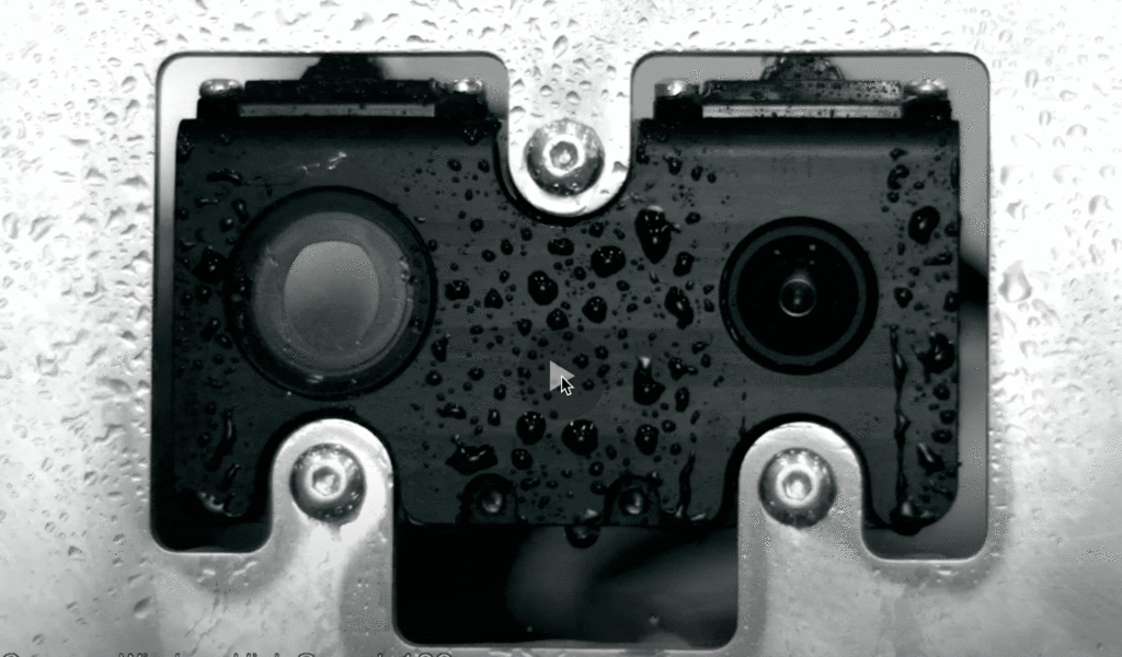 the sensor cleaning system clearing water from the surface of a camera lens