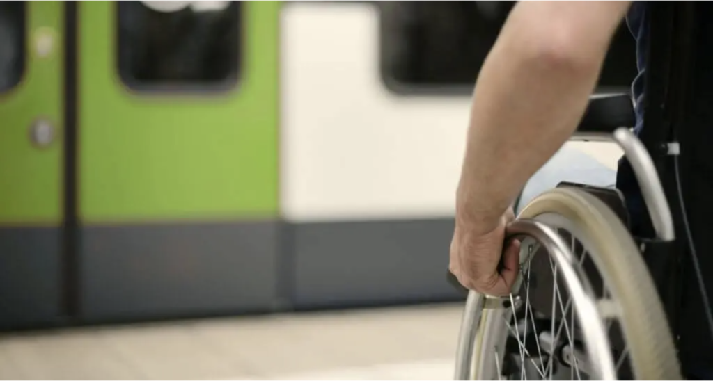 An image showing a person pushing a wheelchair toward a train door