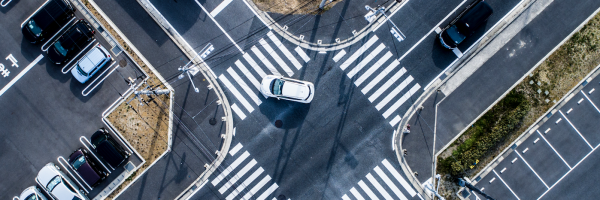 A birds-eye view of a car turning at a four way intersection