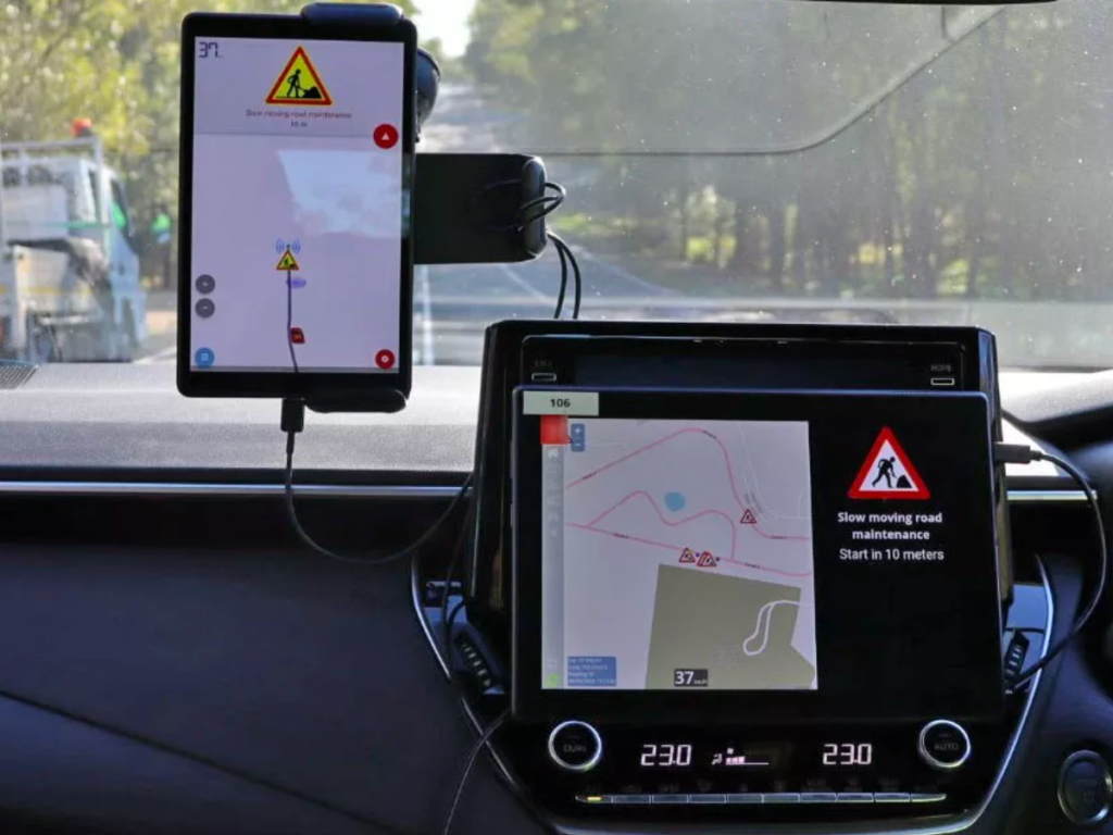 a phone on a dashboard showing ad hoc roadwork information