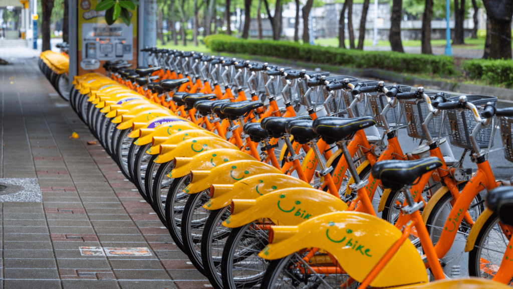 A long line of yellow and orange e-bikes in a city