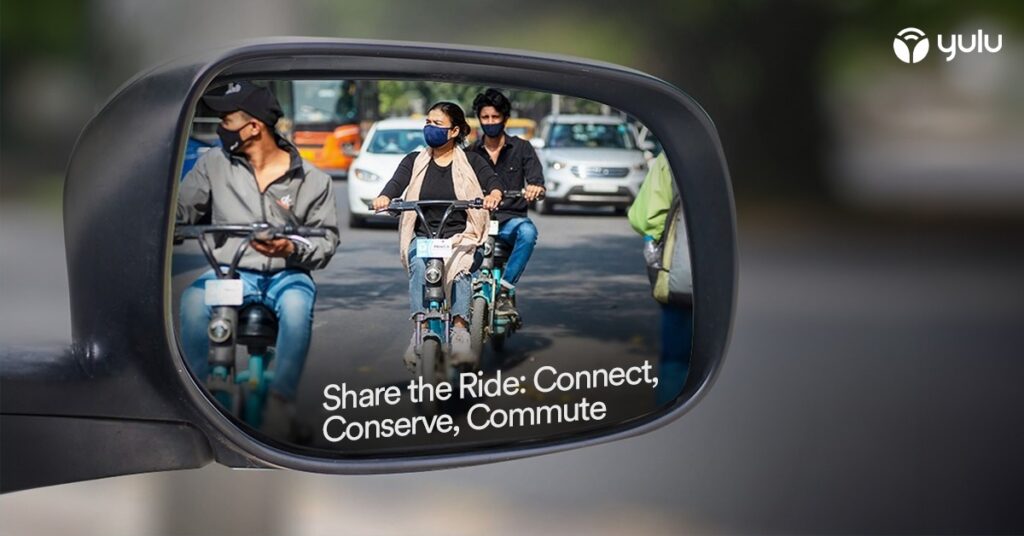 Several people riding electric bikes and wearing masks showin in a side mirror of a car