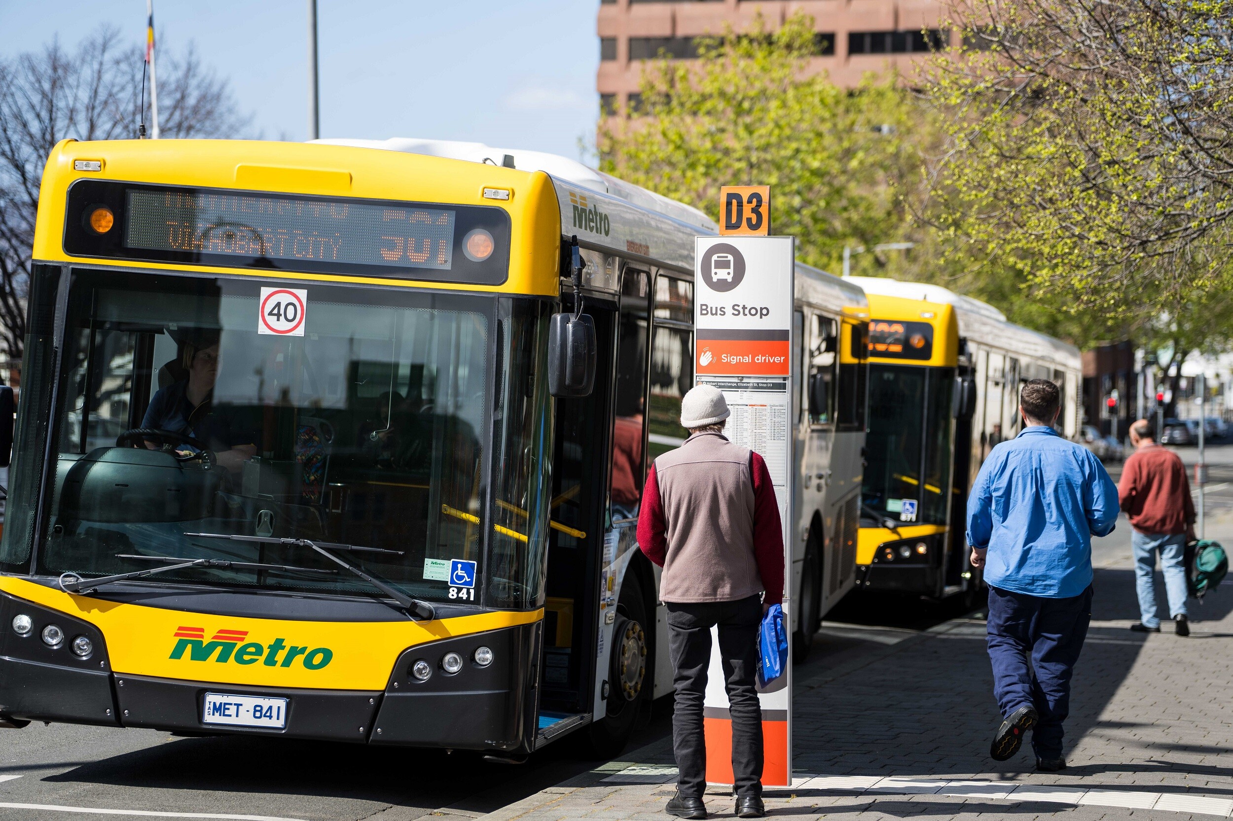 Yellow and black bus parked at a bus stop