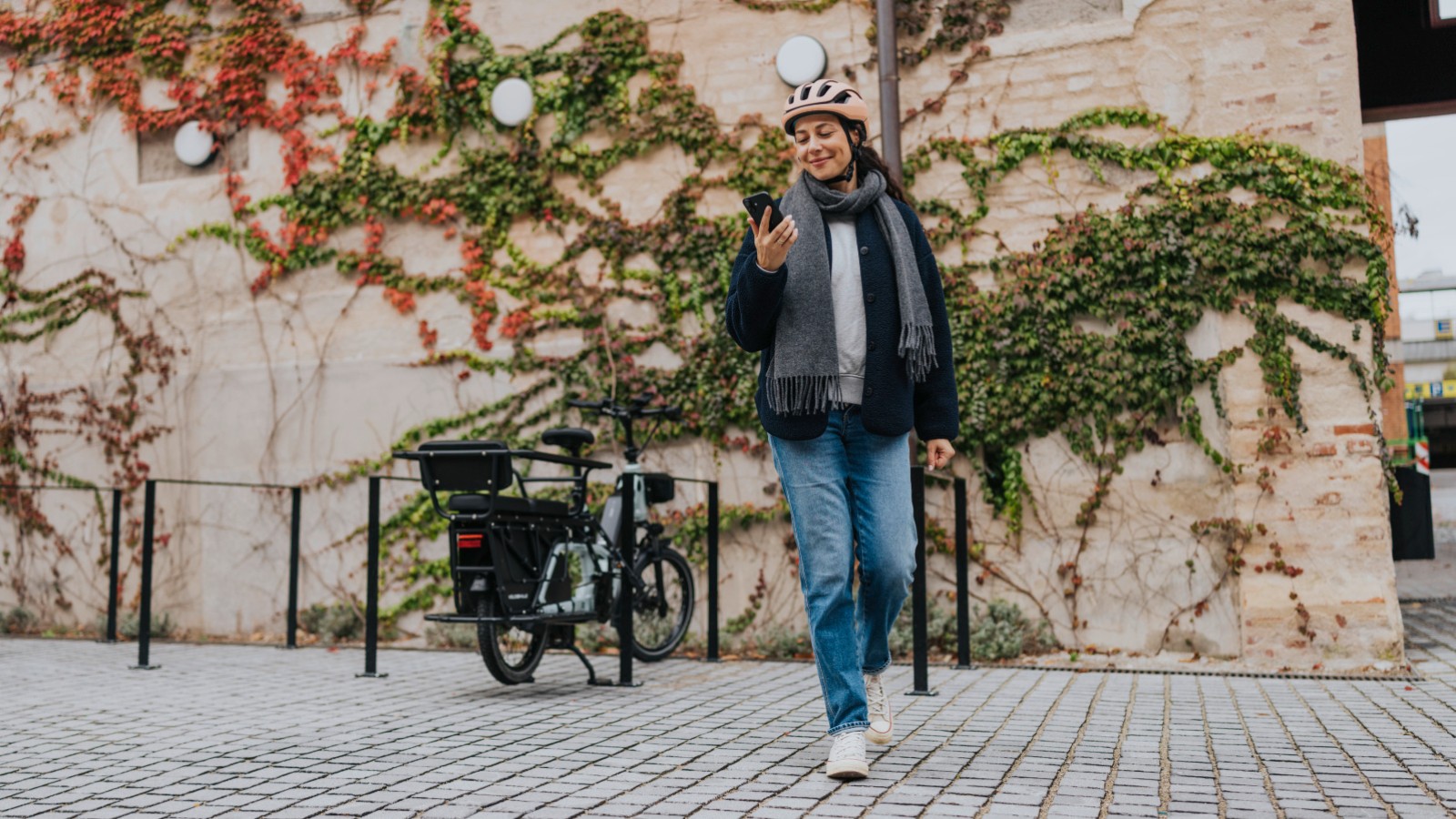 A woman happily looking at her phone by an eBike