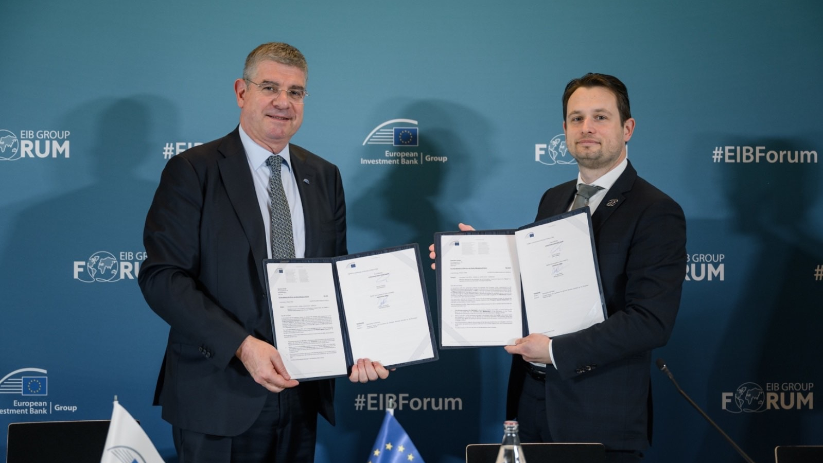 Two people holding contracts