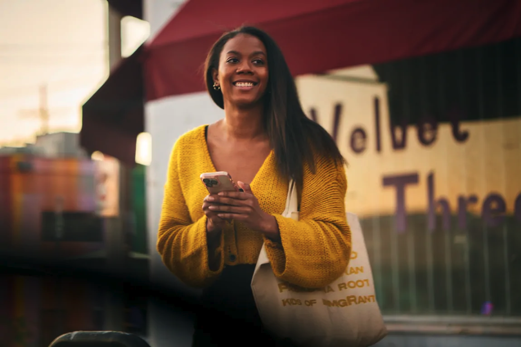 A woman happily holding her phone