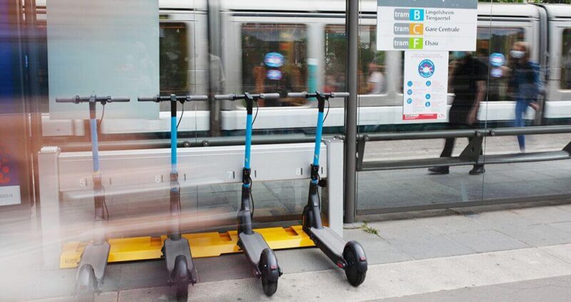 Scooters on charge at a bus stop